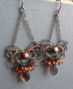 Silver filigree chandelier earrings with patina, smoky quartz, rhodolite garnet, and carnelian beads clustered at the bottom