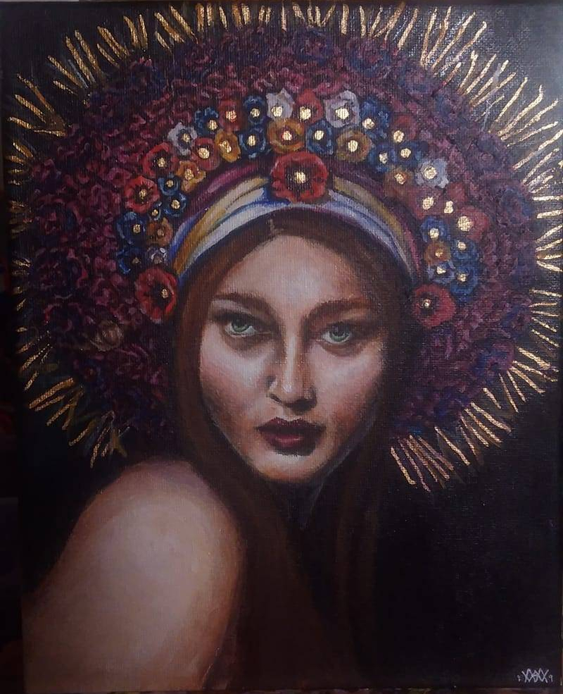 A painting of an auburn-haired woman with green eyes. She is illuminated in a dark room and wears a large multi-color flower crown with gold leafing throughout